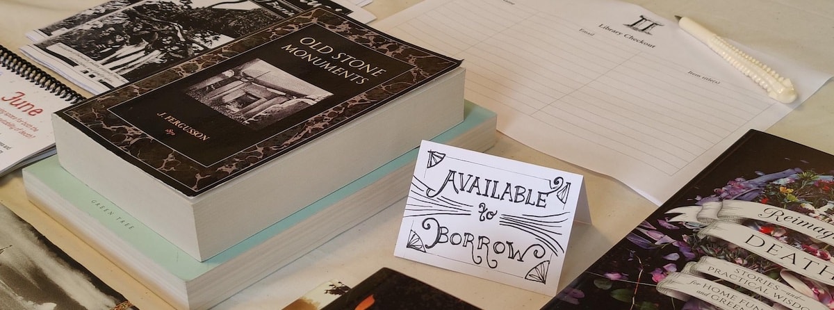 Books on a table beside a sign that indicates that they are available to borrow