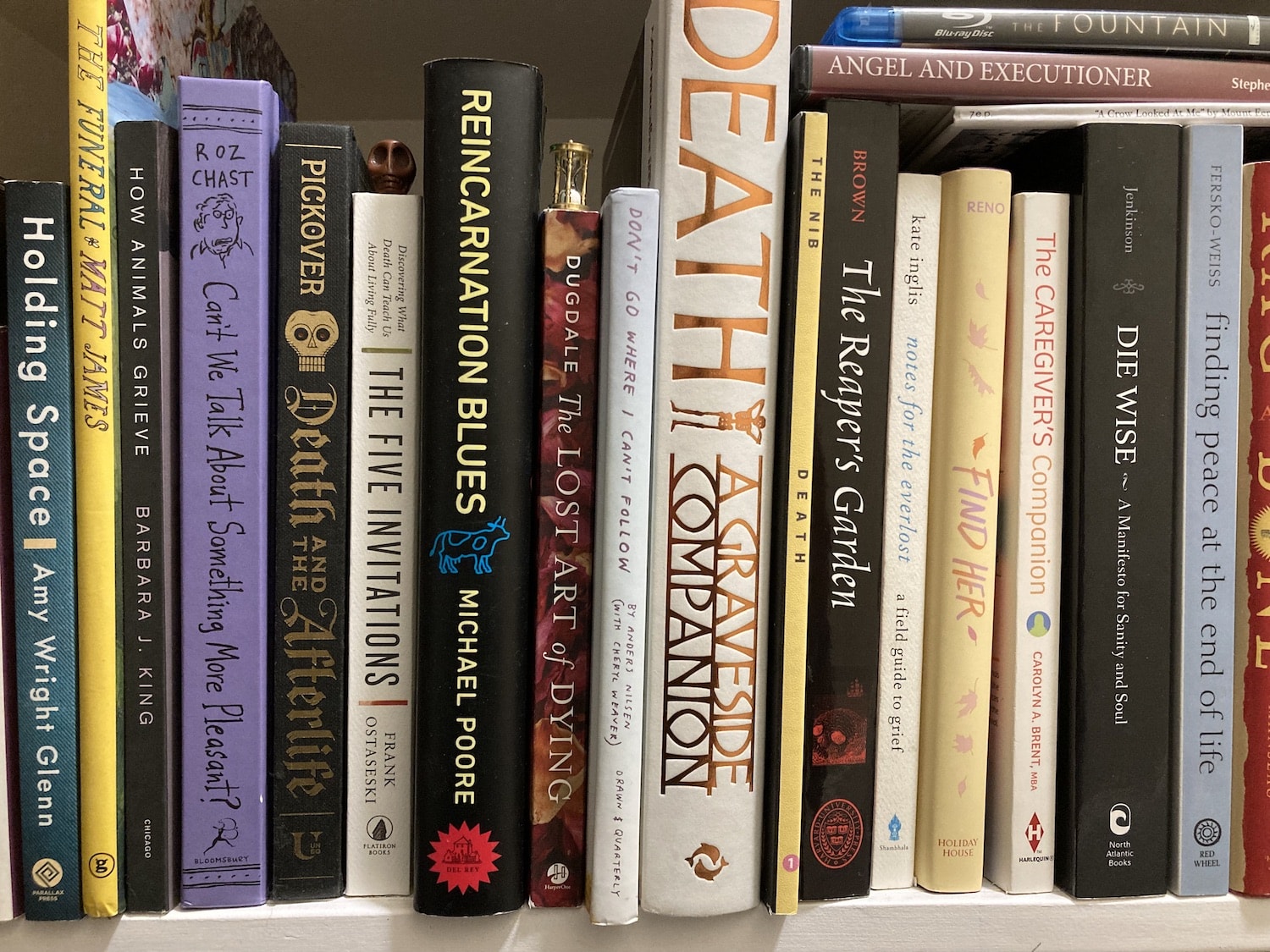 A bookshelf filled with a variety of items exploring death & dying